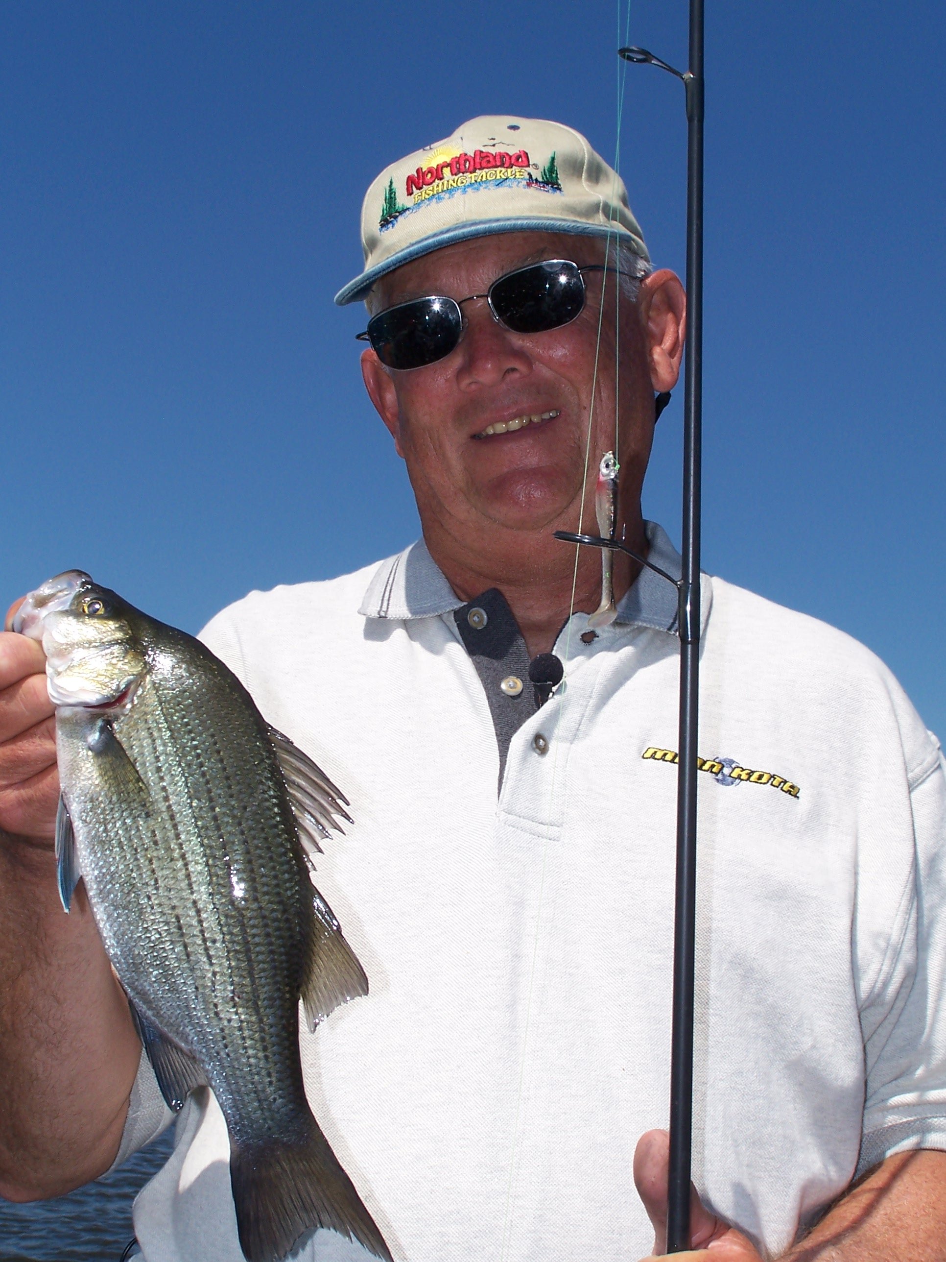 John Stears holding up up a white bass he caught.