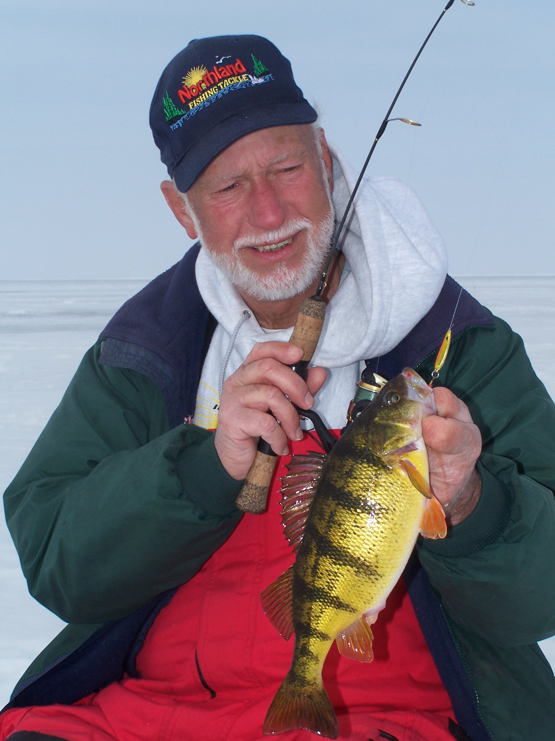 Gary Roach holding up a yellow perch he caught ice fishing.