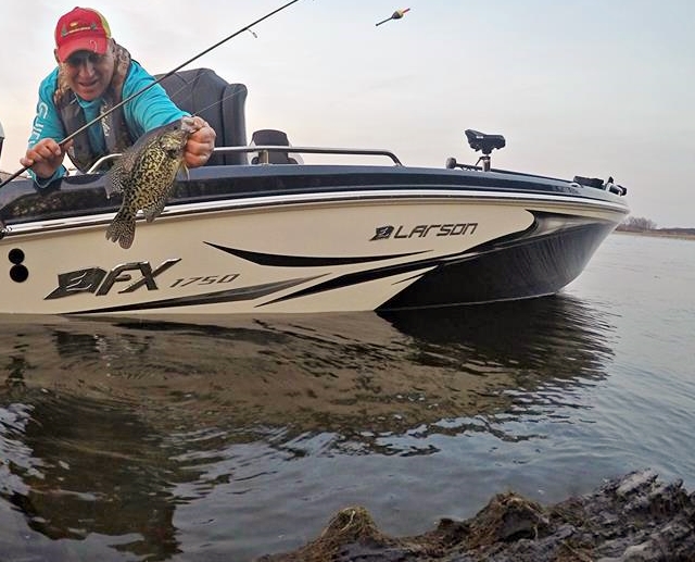 Mike Frisch bringing a crappie out of the water caught under a slip bobber.