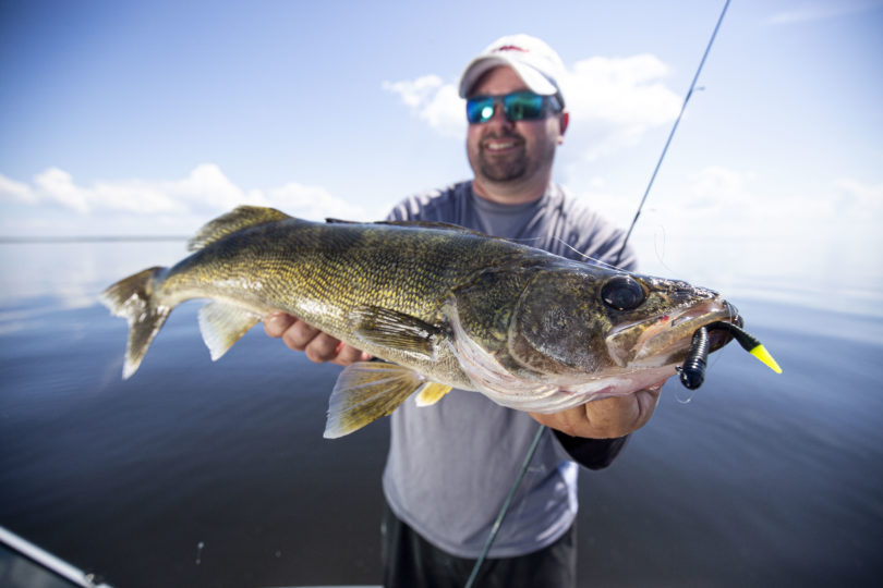 Angler with a walleye caught on a jig and plastic combo