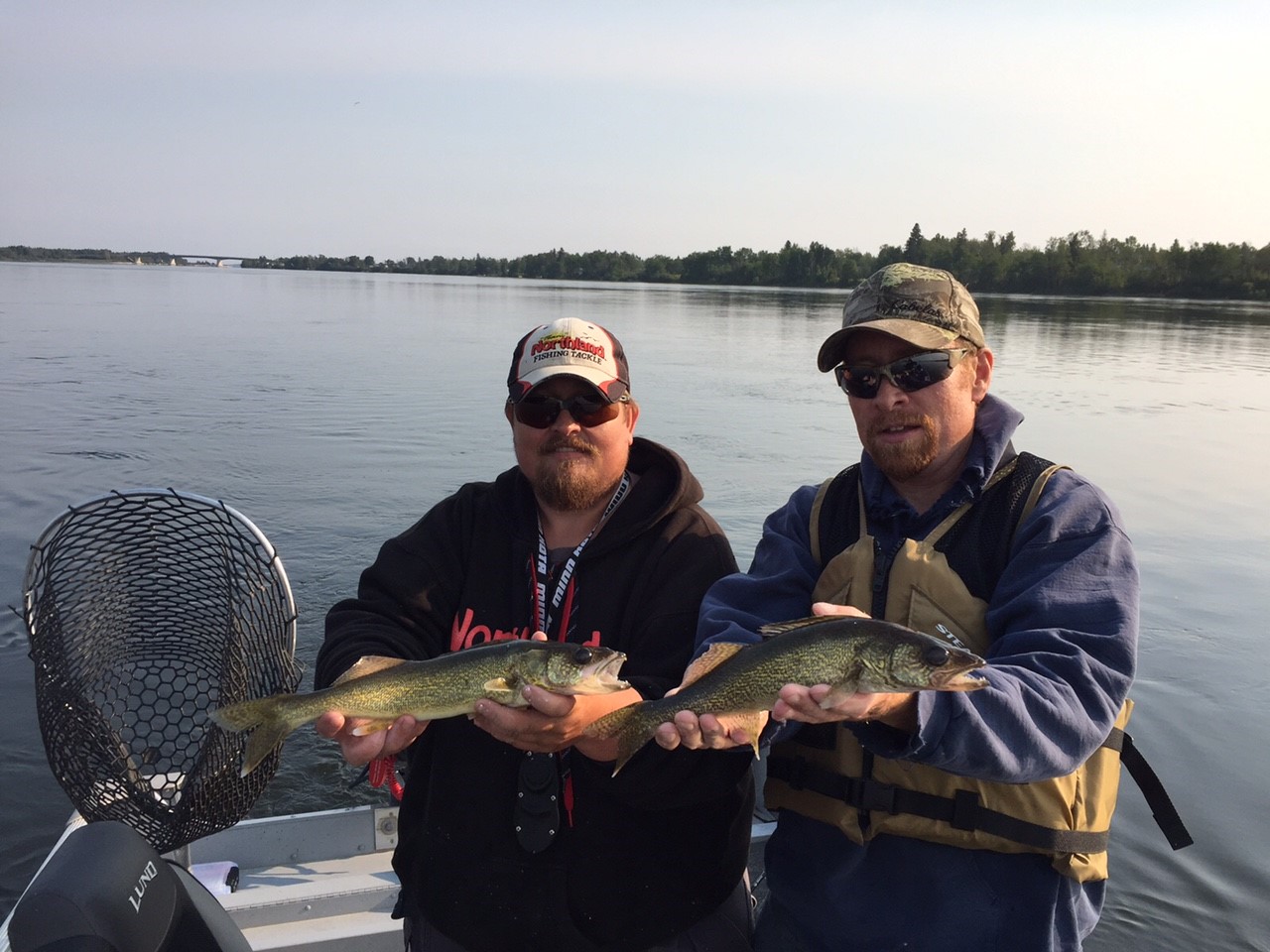 Two anglers holding up walleyes they caught fishing in Manitoba.