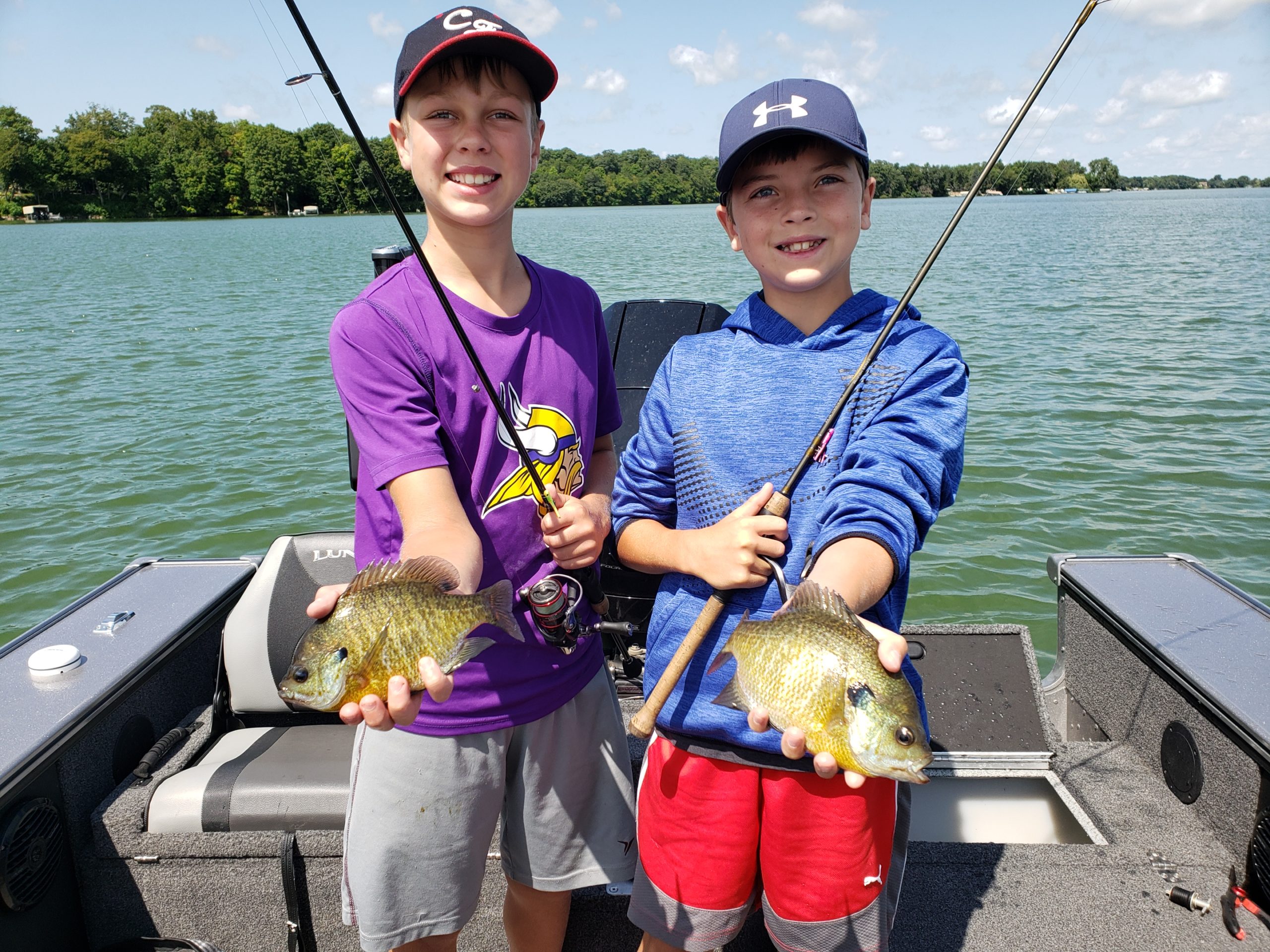 Two youth fisherman holding up bluegills they caught