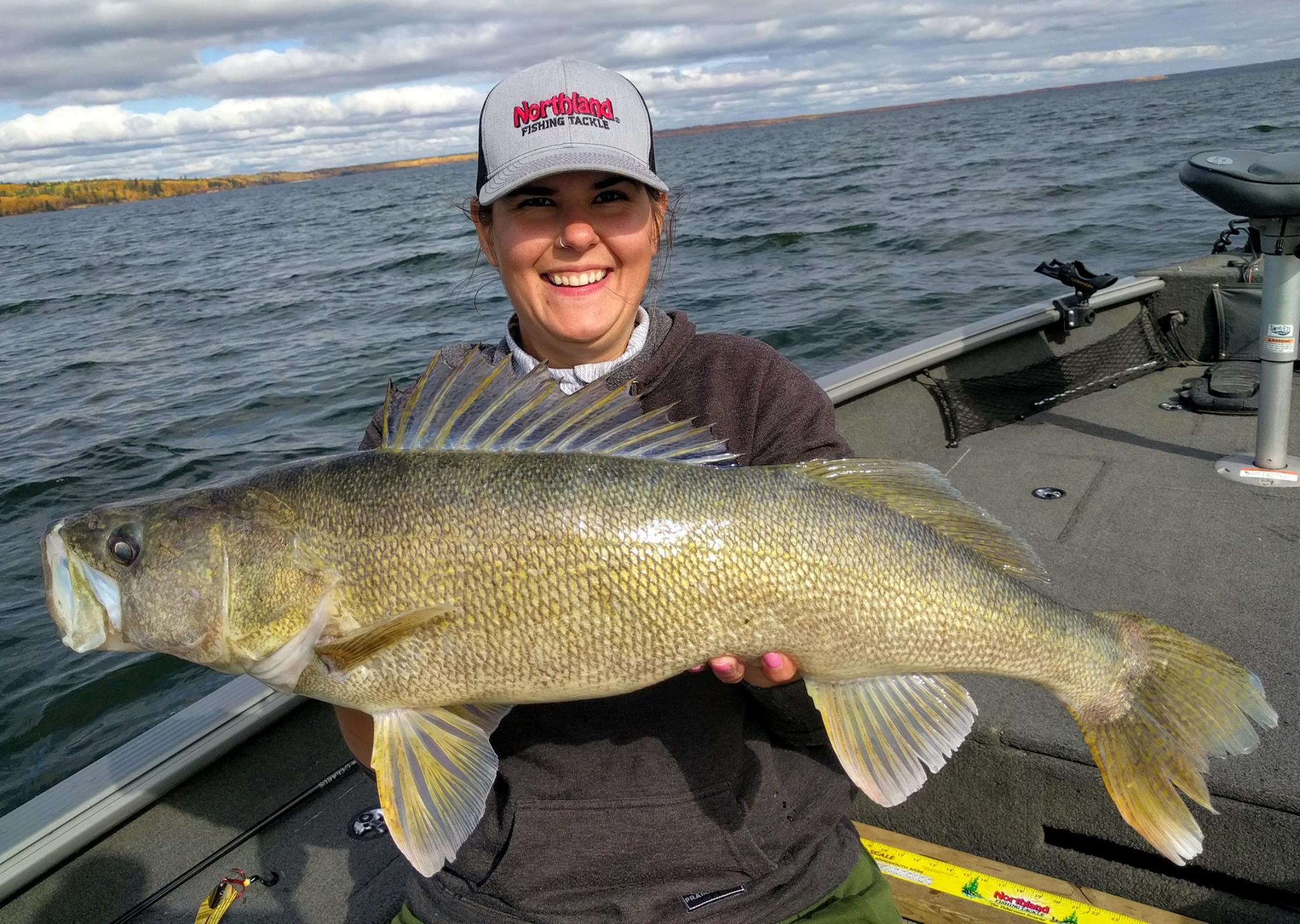 Female angler holding up a big walleye she caught.