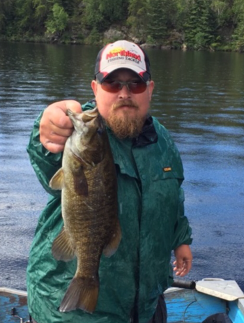 Angler showing off a morning time smallmouth he caught.