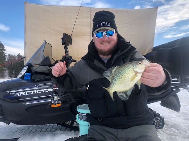 Angler with a late ice fishing season crappie.