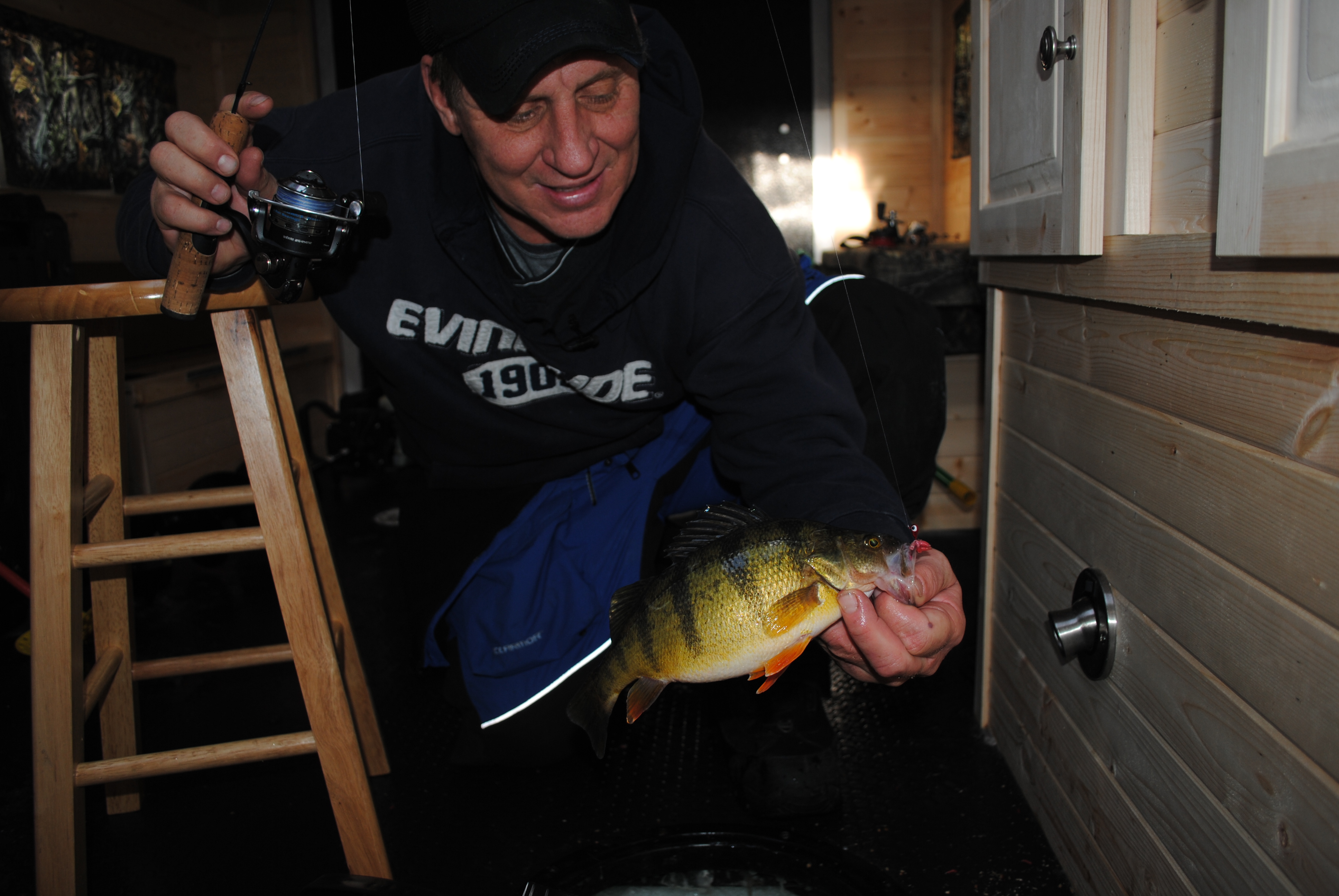 Mike Frisch with a yellow perch he caught in a ice house.