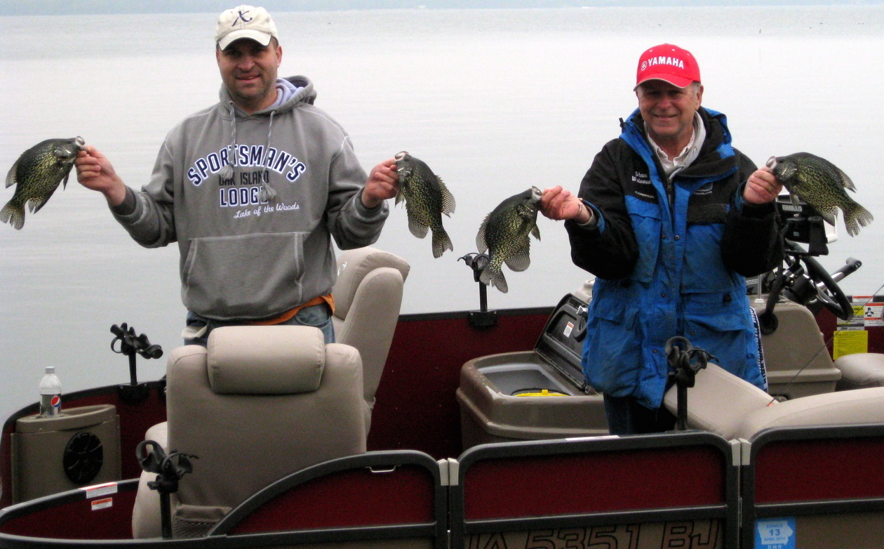 Two anglers showing of crappies they caught fishing Lake Okoboji.