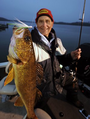 Fisherman holding up a walleye he caught fishing a hair jig.