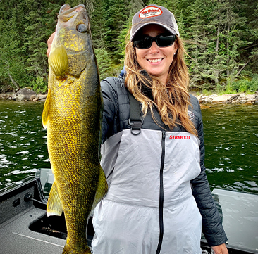 Female fisherman holding up a walleye she caught fishing.