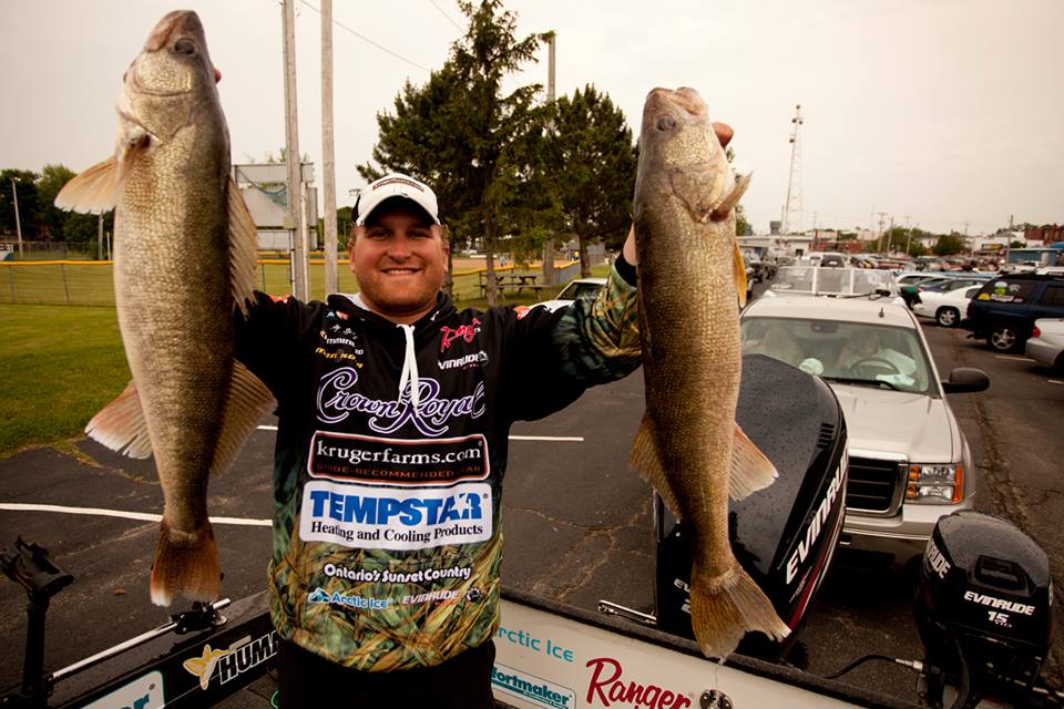 Dusty Minke holding up two walleyes he caught in a tournament