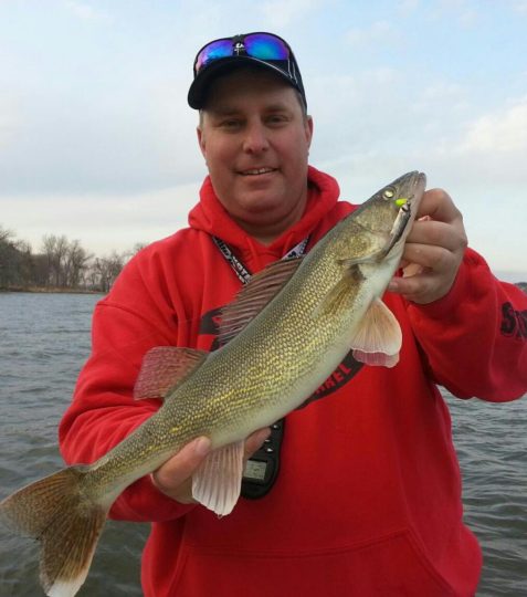 Angler holding up a walleye caught on a jig.