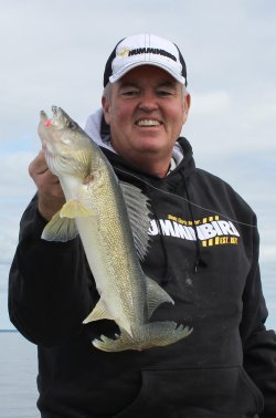 Fisherman holding up a walleye that he caught on a jig.
