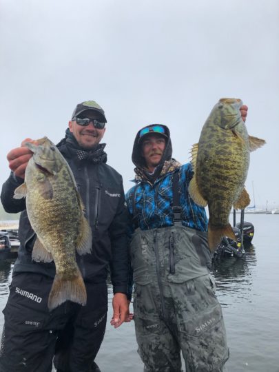 Jeff 'Gussy' Gustafson and Seth Feider holding up smallmouth bass they caught.