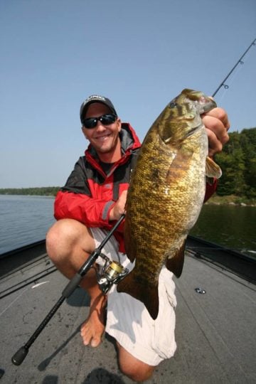 BASS Elite Series Pro Gussy holding a smallmouth bass