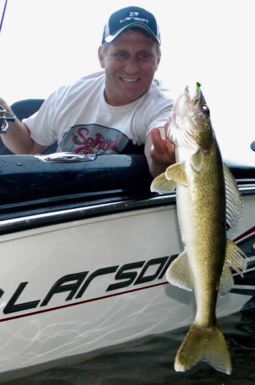 Mike Frisch holding up a walleye he caught fishing.