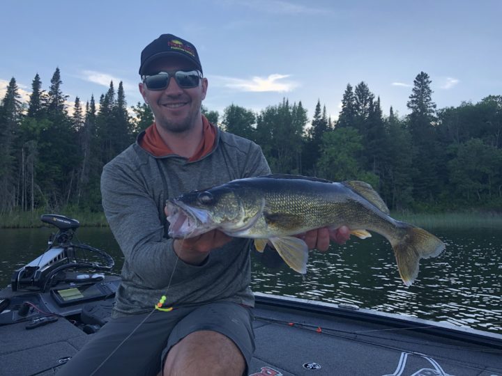 Gussy holding up a walleye he caught.