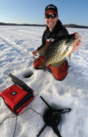 Fisherman with a crappie he caught while ice fishing.
