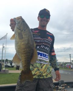 Jeff 'Gussy' Gustafson holding up a smallmouth bass that he caught in a tournament.