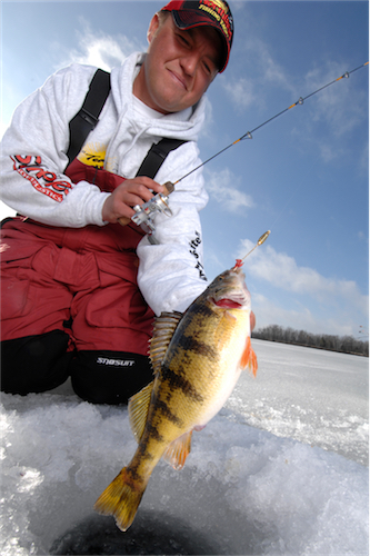 Tony Roach showing off a yellow perch he caught while ice fishing.