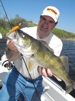 Jason Mitchell holding up a walleye he caught while fishing in the spring.