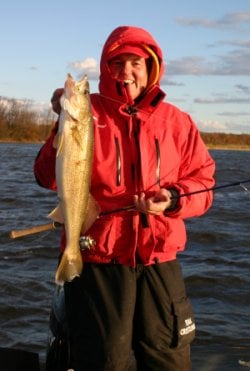 Fisherman holding up an early season walleye