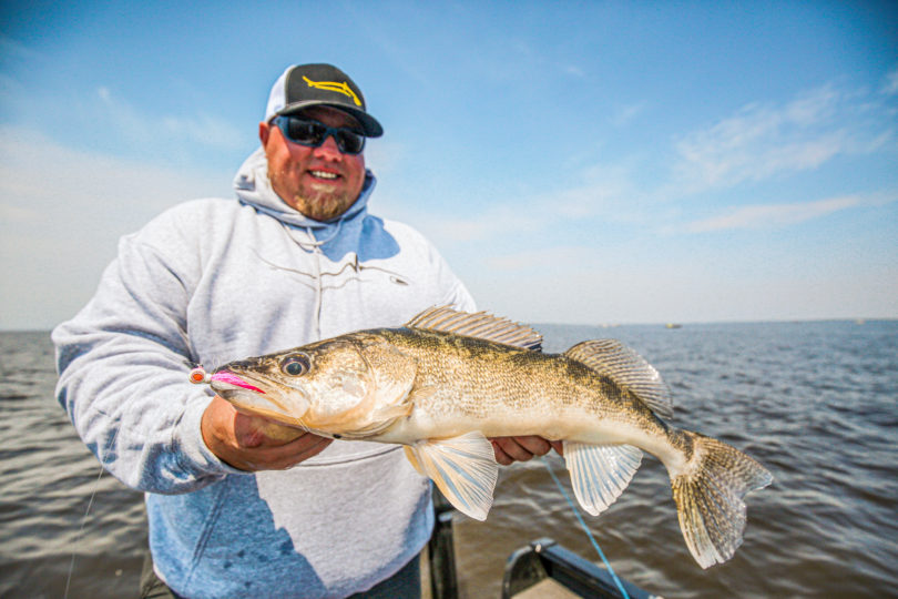 Fisherman holding up a walleye he caught on the Deep-Vee Bucktail jig