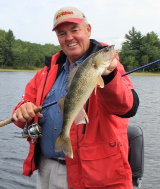 Fisherman holding up a walleye he caught.