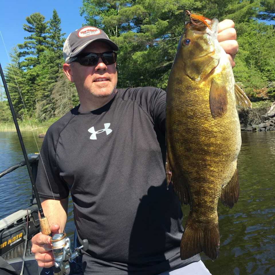 Travis Petersonwith a smallmouth bass he caught on a hair jig