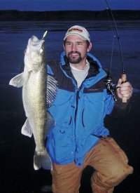 Fisherman with a walleye caught at dusk.