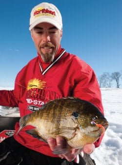 Northland Tackle ice fisherman with a bluegill caught on an Impulse Tapeworm