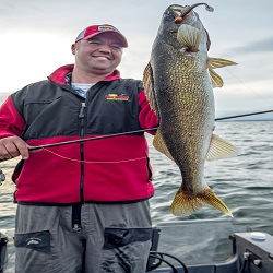 Tony Roach holding up a walleye he caught on a jig