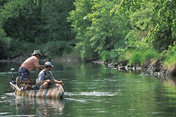 Two anglers fishing in a canoe.