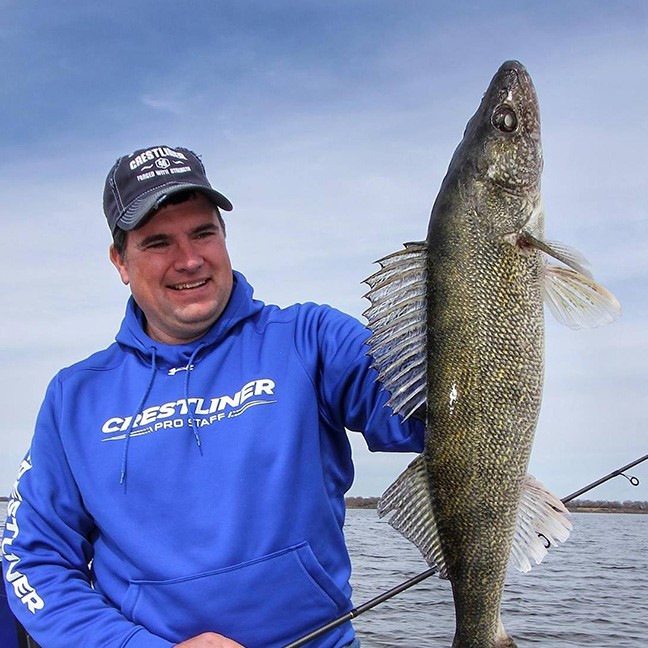 Angler holding up a walleye he caught on a crankbait