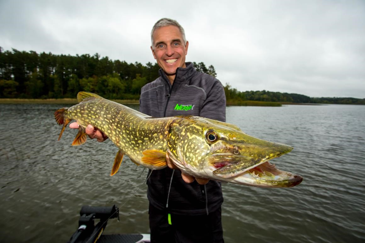 Cheep Leer holding a big northern pike he caught.