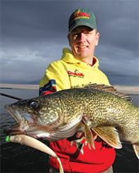 Eric Naig holding up an open water walleye he caught fishing.