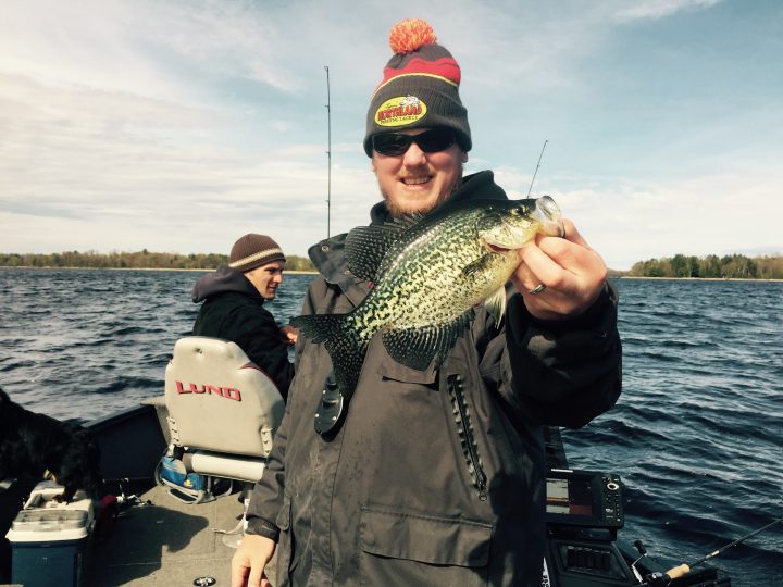 Fisherman holding up a crappie they caught.