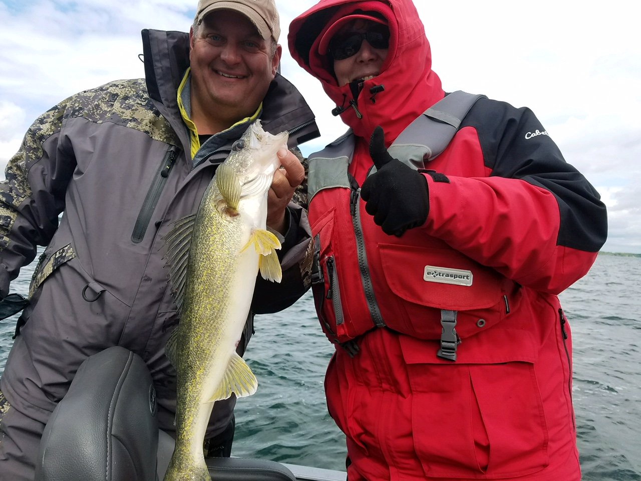 Two anglers holding up a cold weather walleye