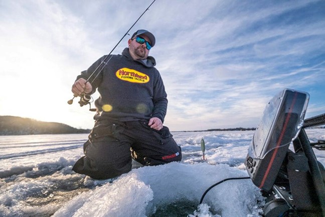 Angler ice fishing on early season ice