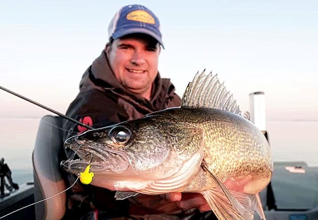 Jason Mitchell holding up a walleye he caught on the Fire-Ball Jig