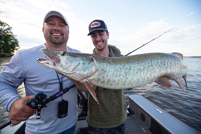 Two anglers with a musky they caught on a Rumble Series crankbait