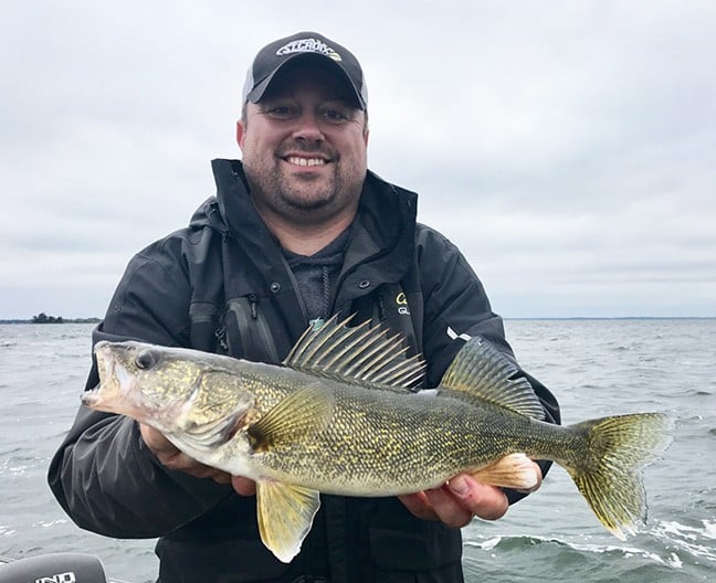 Joel Nelson holding up a spring river walleye he caught