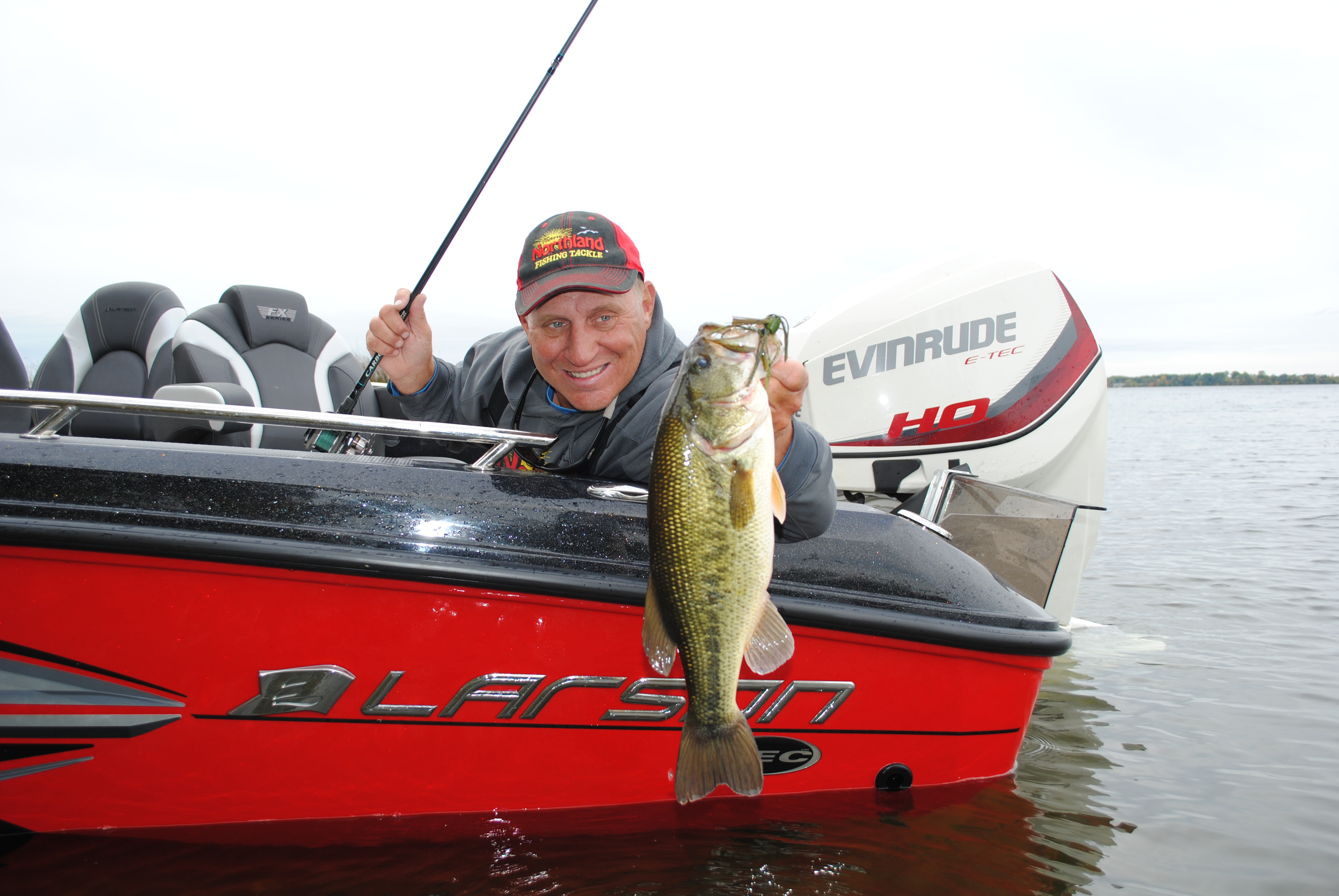 Mike Frisch holding up a largemouth bass he caught on a weedline.